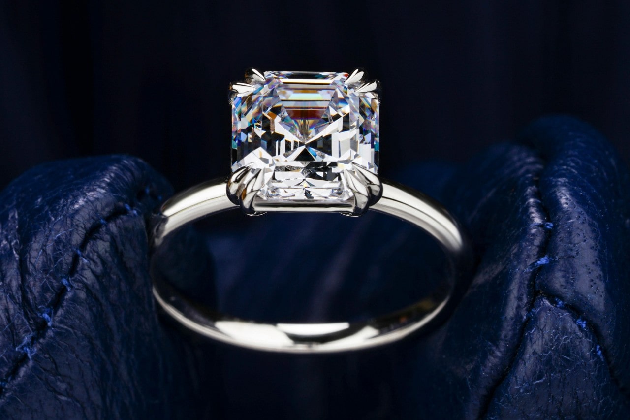 a white gold engagement ring with an asscher cut center diamond