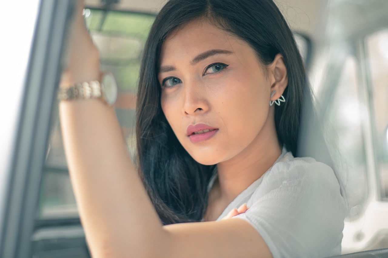 A captivating young woman with a casual style wearing fashionable earrings and a wristwatch.
