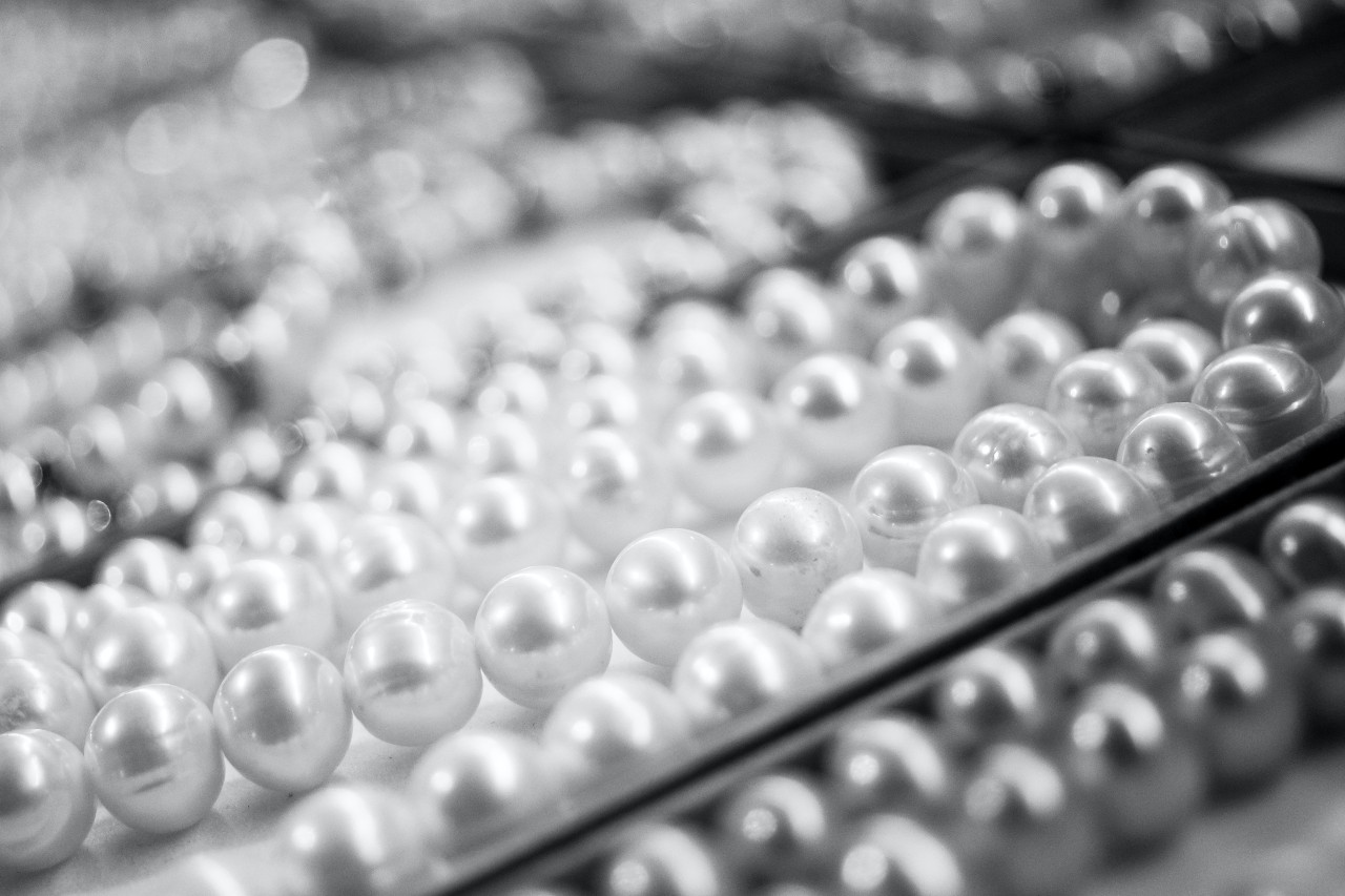 A black and white close-up shot  of several strings of pearls.