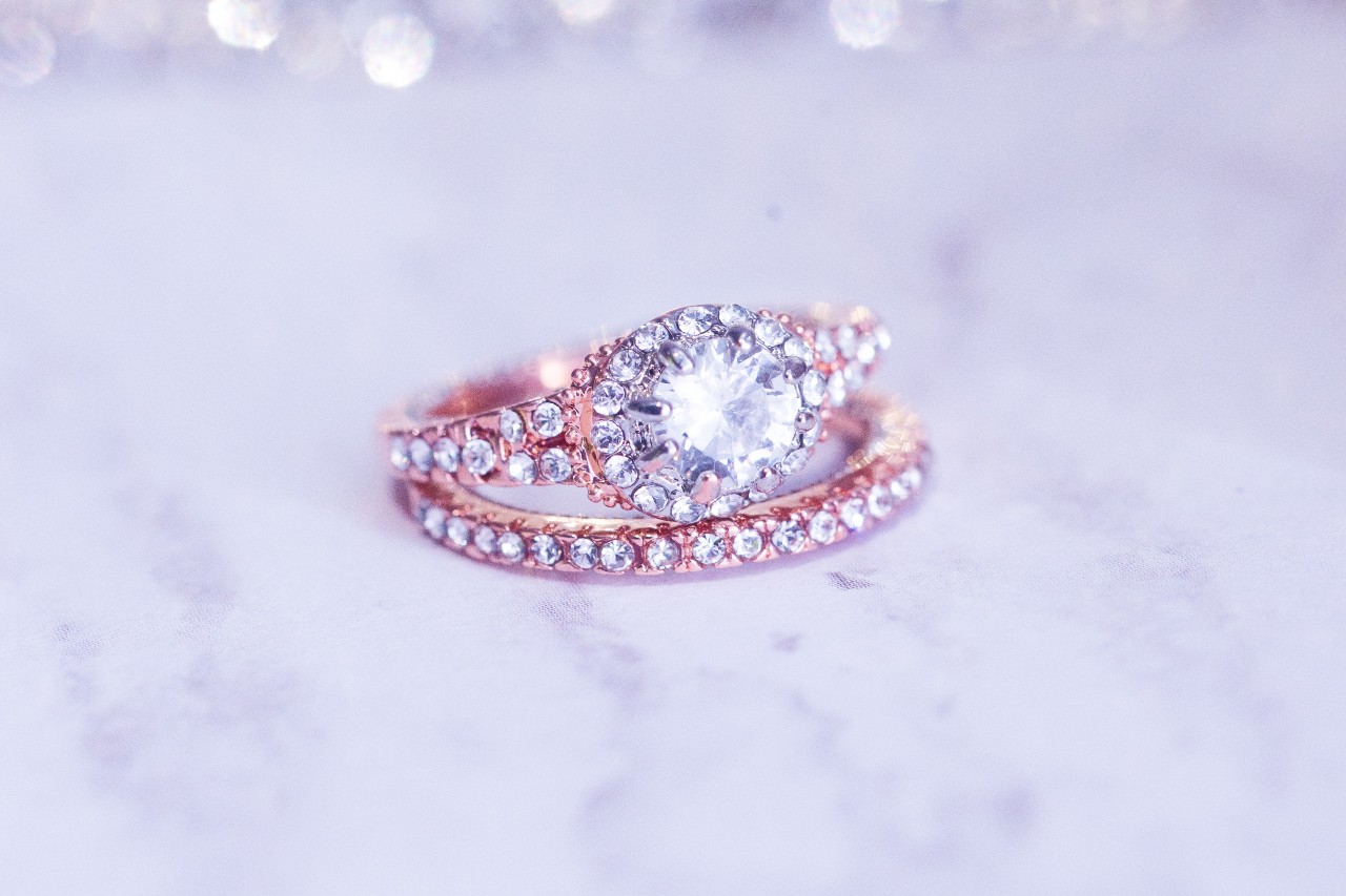 A close-up of a dazzling rose gold engagement ring and matching eternity band.