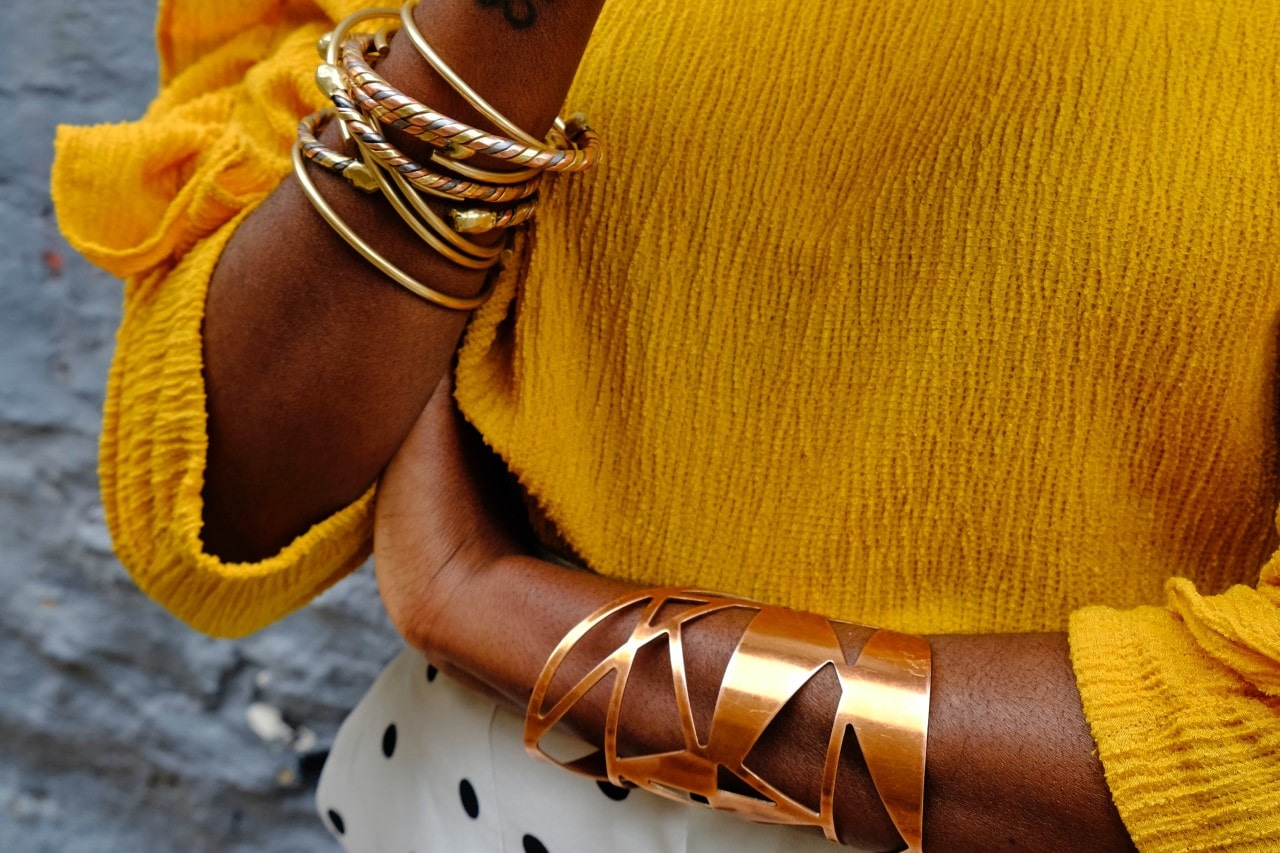a lady with a yellow shirt wearing gold bracelets