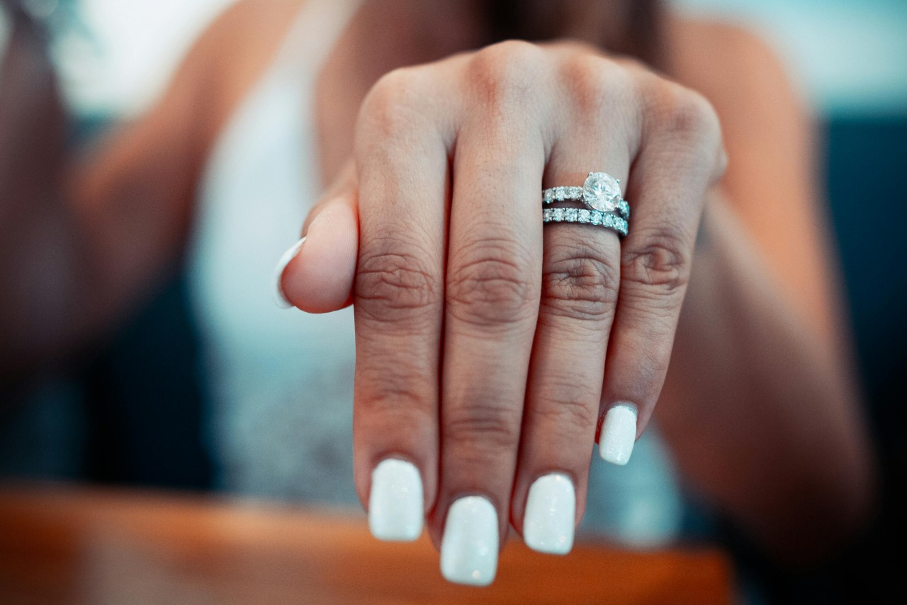 A bride shows off her white gold wedding ring set.