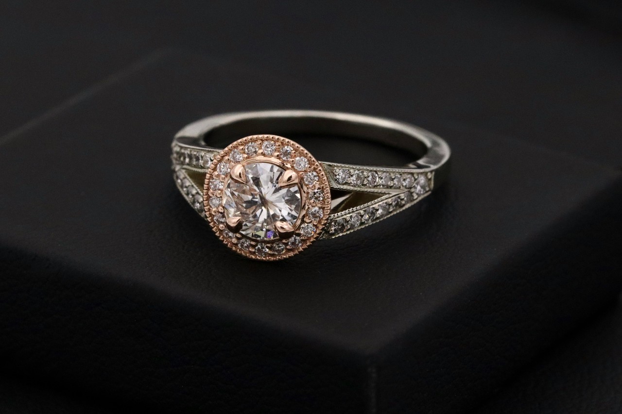 A close-up of a vintage engagement ring on a black background.